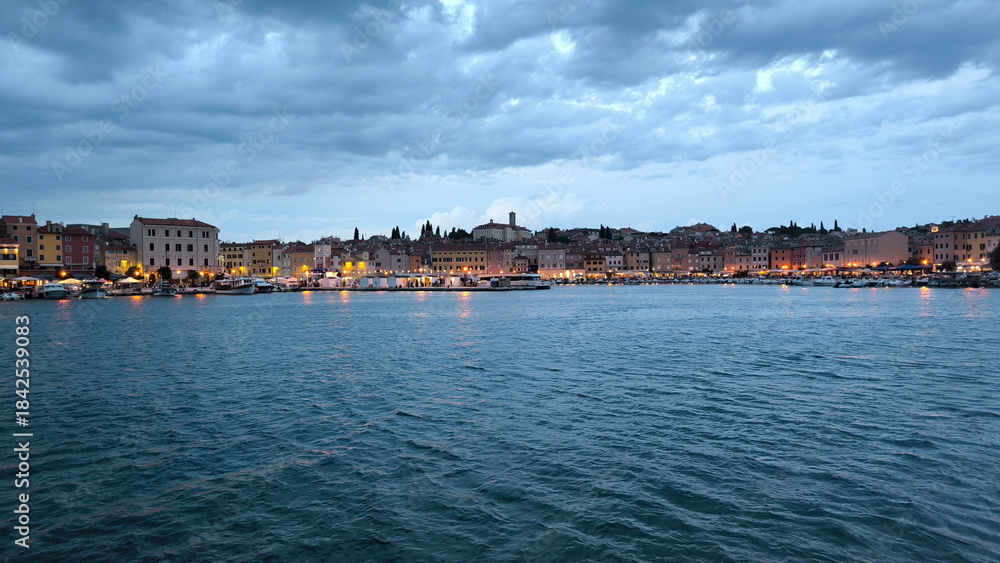Fototapeta premium panorama of illuminated Rovinj seen from the harbor at dusk