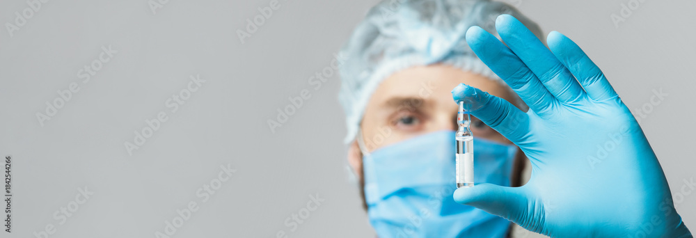 Ταπετσαρία A healthcare professional in blue gloves and a mask shows a syringe filled with a vaccine