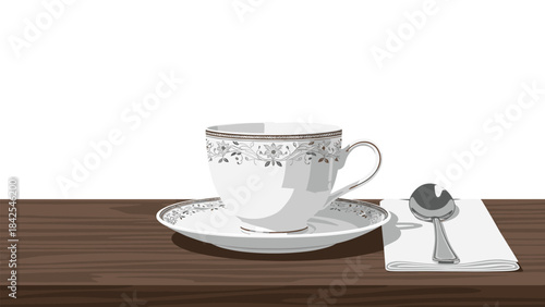 A delicate white teacup and saucer with silver trim on a wooden table with a spoon on a napkin