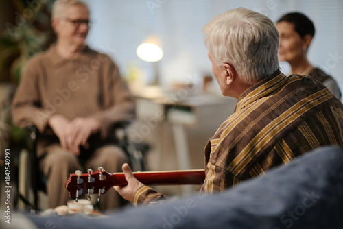 Foto Senior Caucasian man playing acoustic guitar for senior Caucasian man with disab