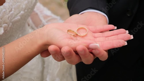 bride and groom holding hands and rings