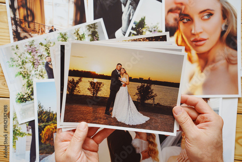 Men's hands put on the table and show wedding photos.