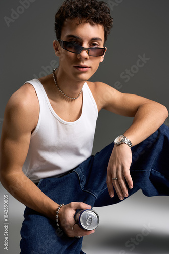 Foto Stylish teenager exuding confidence in tank top and sunglasses against grey back