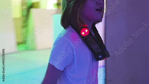 Child explores laser tag arena with colorful lights