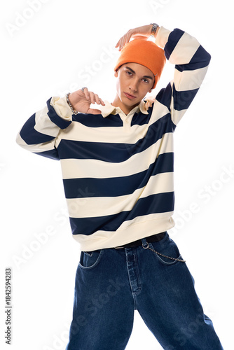 Stylish teenager showcases trendy fashion with stripes and vibrant orange hat