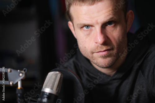 podcaster with microphone copy space background image, selective focus image, horizontal, white male, model, handsome guy