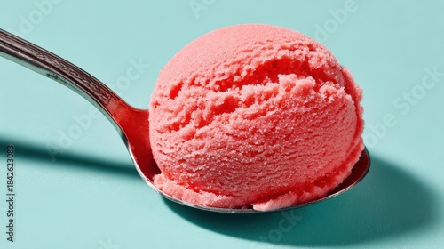 Delicious Pink Sorbet on Silver Spoon Against Blue Background