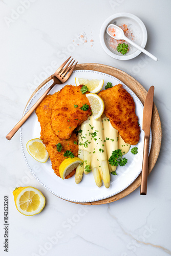 White asparagus with fried schnitzel, lemon and hollandaise sauce