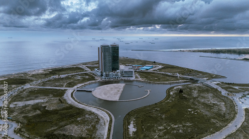 Aerial view of modern architecture meeting the vast ocean under a brooding sky at Eko Atlantic, Lagos, Lagos, Nigeria.
