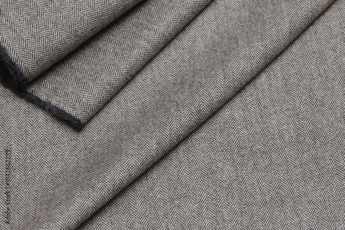 Tableau sur toile Close-up view of classic English tweed wool fabric in a fine gray and black herringbone weave