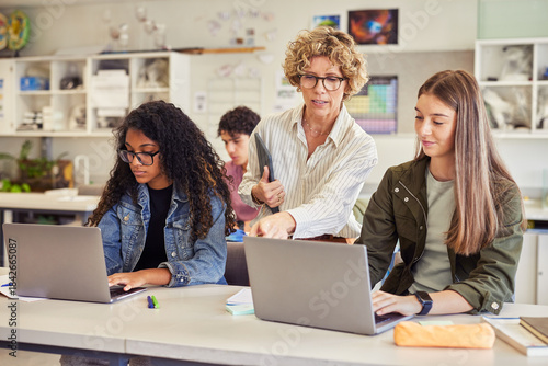 Teacher assisting student during computer class