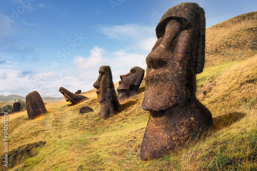 Canvas Print Abandoned moai statues, partially buried on the slope of Volcano Rano Raraku at the Rano Raraku Archaeological Site, Rapa Nui (Easter Island), Chile