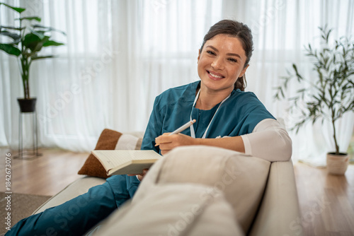Nurse caregiver smiling and writing notes for home health