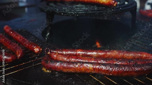 Sausages grilling on hot barbecue street food.