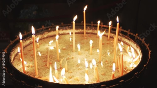 Burning candles on altar in church.