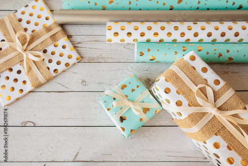 Wallpaper Mural Flat lay of assorted gift wrapping paper rolls and beautifully wrapped boxes with bows on rustic wood. Perfect for DIY packaging, festive prep, or gifting inspiration Torontodigital.ca