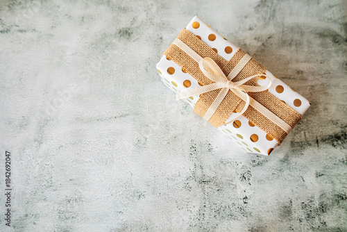Wallpaper Mural Single elegant present with polka dots and jute ribbon on concrete backdrop. Perfect layout for product mockups, packaging tutorials, and holiday marketing visuals Torontodigital.ca