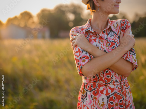 young woman embracing herself, self-love in action, mental health advocate, practicing self-care for finding inner peace, in European countryside