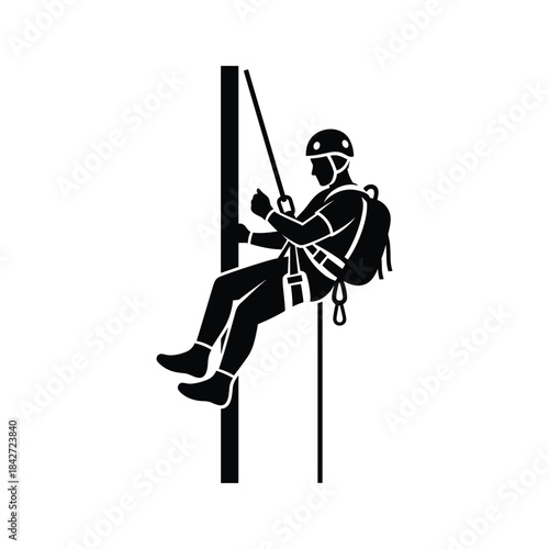 Person climbing down a wall with rope and harness
