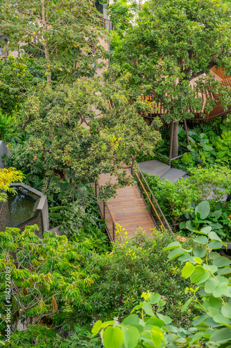 Walkways and wooden paths in Dusit Park on a Bangkok rooftop, surrounded by fresh greenery and offering elevated city views that blend modern design with calm natural space.