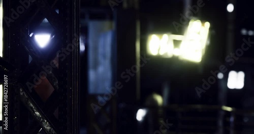 Exploring an abandoned building at night reveals a mix of crumbling structures and neon signs illuminating the dark corners. The atmosphere is eerie yet captivating, inviting curiosity.