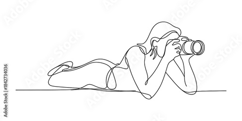 Continuous line art of a woman lying down and taking a photograph with a professional camera Vector, illustration