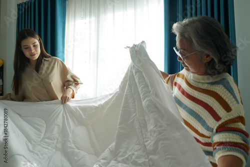 Wallpaper Mural Caregiver helping elderly woman making bed at home Torontodigital.ca