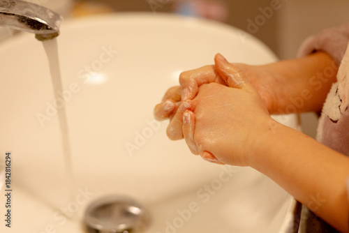 Close up delle mani di una ragazza mentre se le lava con acqua e sapone