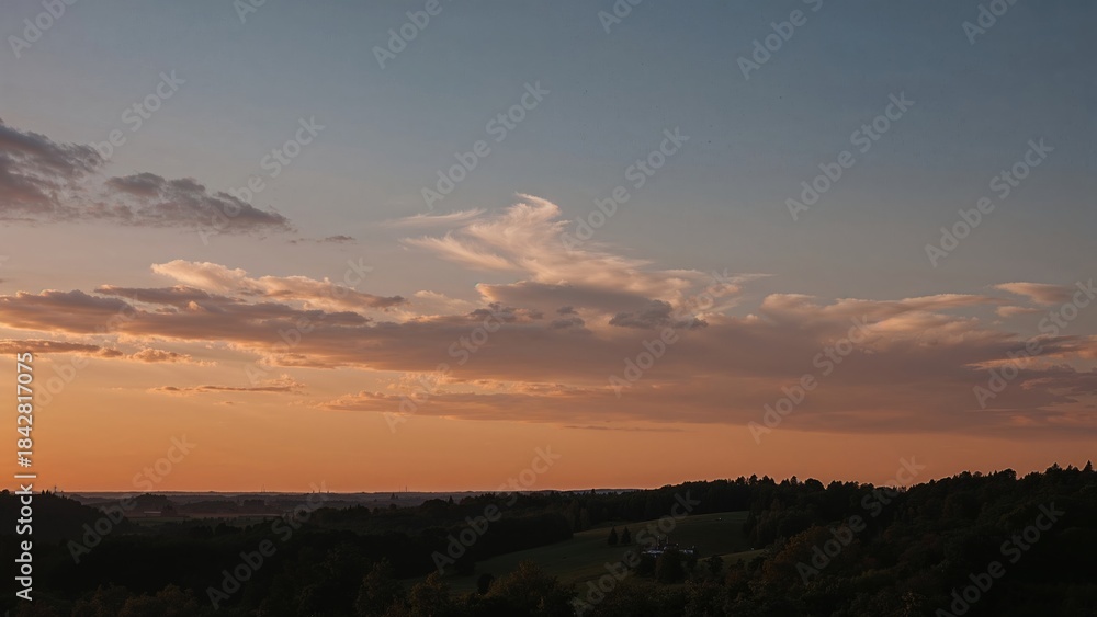 Obraz premium Sunset sky with clouds over a landscape, natural scenery.