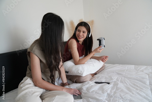 Wallpaper Mural Young women playing video games together in living room. Torontodigital.ca
