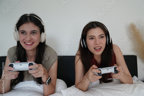 Wallpaper Mural Young women playing video games together in living room. Torontodigital.ca