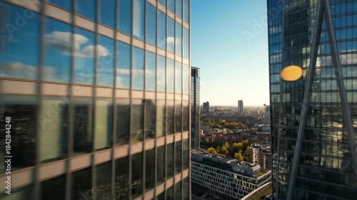 Modern skyscrapers reflecting sunlight against a clear blue sky aerial view