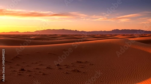 Majestic desert landscape at sunset featuring rolling sand dunes and distant mountains showcasing