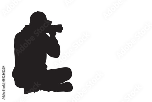 Photographer Sitting Down Taking Picture with Camera Silhouette