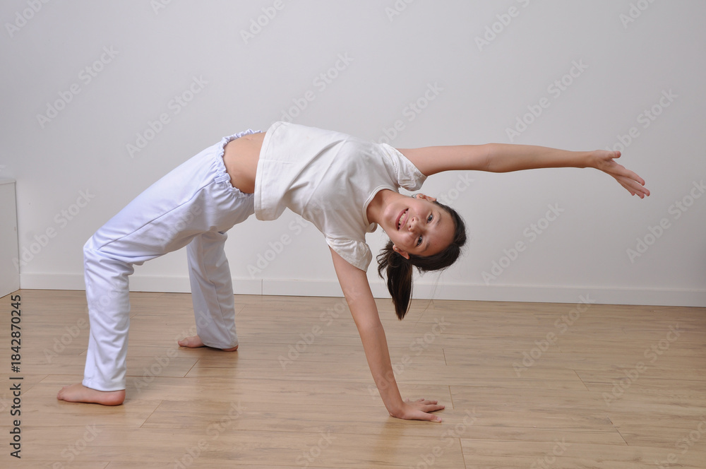 Obraz premium menina faz treino de capoeira e flexibilidade
