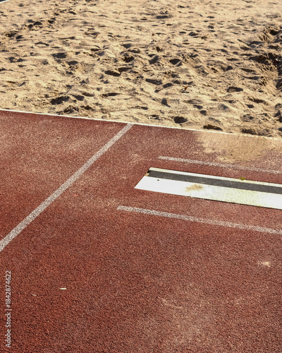 Long jump pit and runway at an outdoor athletics field on a sunny day