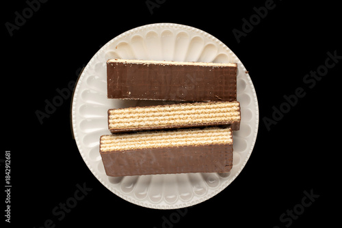 Sweet chocolate wafers cut into pieces, top view, macro.