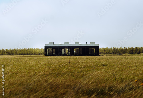 Foto Contemporary black minimalist house standing alone in an open field in Iceland