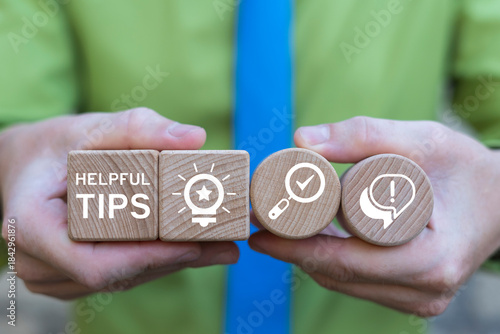 Business person holding wooden blocks with icons sees the inscription HELPFUL TIPS. Helpful Tips Business Concept. Top tip and quick advice.