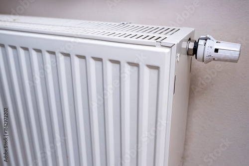 Wallpaper Mural Detailed close-up of a white radiator with control knob, positioned against a neutral wall. Ideal for showcasing heating solutions or home improvement concepts. Torontodigital.ca