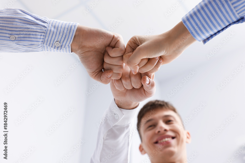 Fototapeta premium People joining hands together indoors, low angle view. Team building