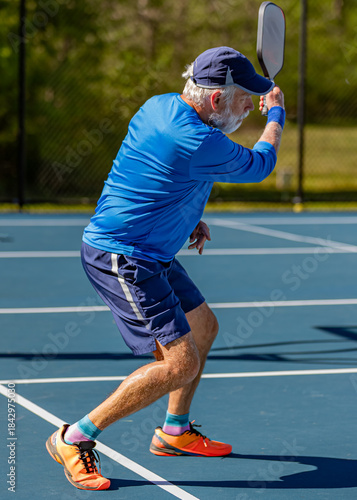 Senior finishes hitting a topspin forehand in a pickleball tournament1