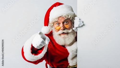 Man in santa costume peeking from behind blank billboard, happy Christmas character holding white board with copy space, new year greeting card template. Cloud Dancer Color of the Year 2026
