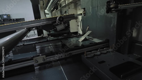 Ski service and tuning automatic machine, conveyor belts for transporting skis moving, while water is sprayed during grinding in background