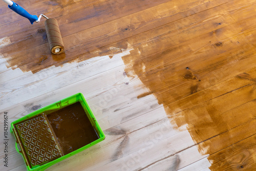 Canvas Print Wooden floor staining with paint roller and tray for home renovation project