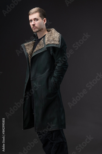 Cyberpunk portrait: man in high-neck coat concealing face, gloomy future aesthetic.