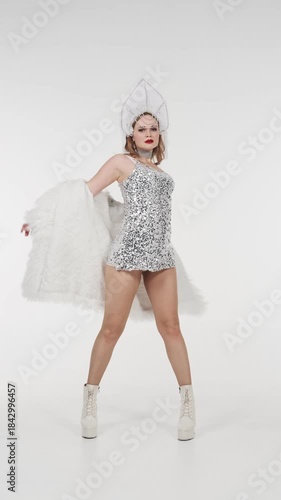 Elegant woman in sparkling snow queen costume performs graceful dance on white background. Festive winter video content for Christmas, New Year events, fashion shows and seasonal marketing
