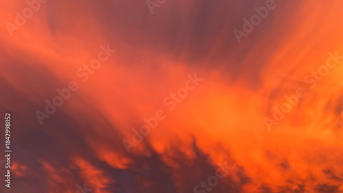 Sunset clouds in fiery orange and red tones mixed with dark purple and black, creating an intense, vibrant, and dramatic appearance.