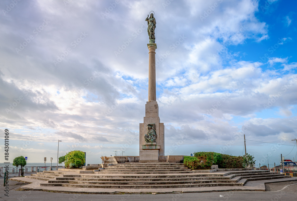 Obraz premium The Monument to the Sailors in Piazza della Concordia, in Salerno, Southern Italy, surmounted by a statue of the Virgin Mary in golden bronze.
