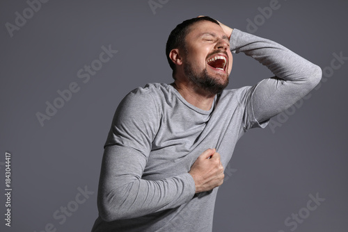 Screaming young man on dark...